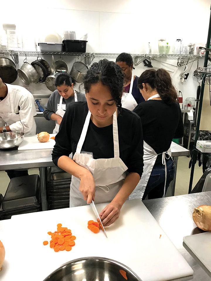 Plant to Plate intern cutting vegetables